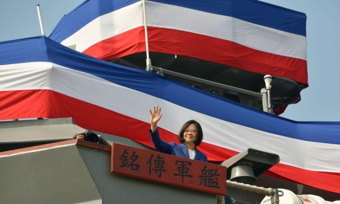Taiwan's President Tsai Ing-wen waves to assembled guests from the deck of the 'Ming Chuan' frigate during a ceremony to commission two Perry-class guided missile frigates from the United States into the Taiwan Navy, in the southern port of Kaohsiung on Nov. 8, 2018. (Chris Stowers/AFP/Getty Images)
