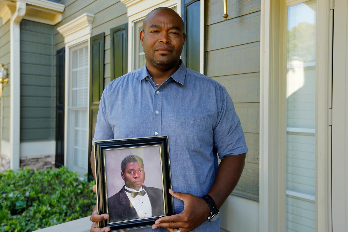 Chris Parks poses with a portrait of his brother Donovan Corey Parks in Powder Springs, Ga. on June 14, 2019. (AP Photo/Andrea Smith)
