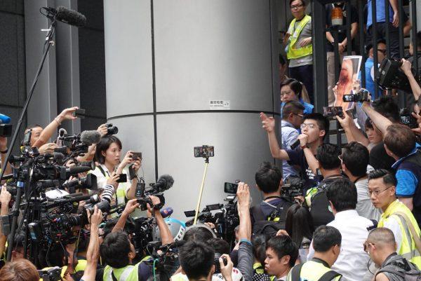 Joshua Wong addresses protesters outside of the Hong Kong Police Headquarters in Wan Chai on June 21, 2019. (Yu Gang/The Epoch Times)