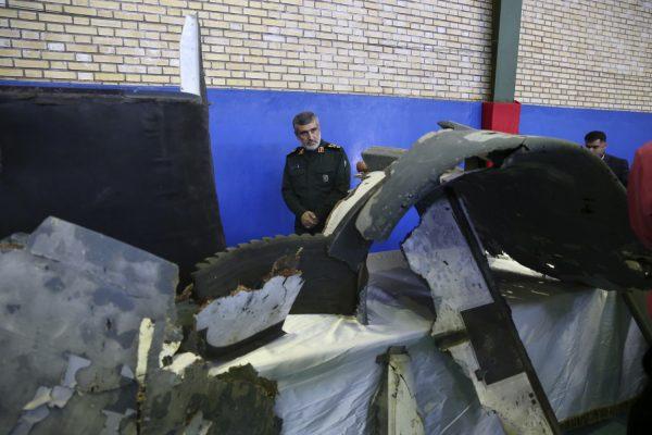 Head of the Revolutionary Guard’s aerospace division Gen. Amir Ali Hajizadeh looks at debris from what the division describes as the U.S. drone which was shot down the day prior in Tehran, Iran on June 21, 2019. (Meghdad Madadi/Tasnim News Agency/via AP)