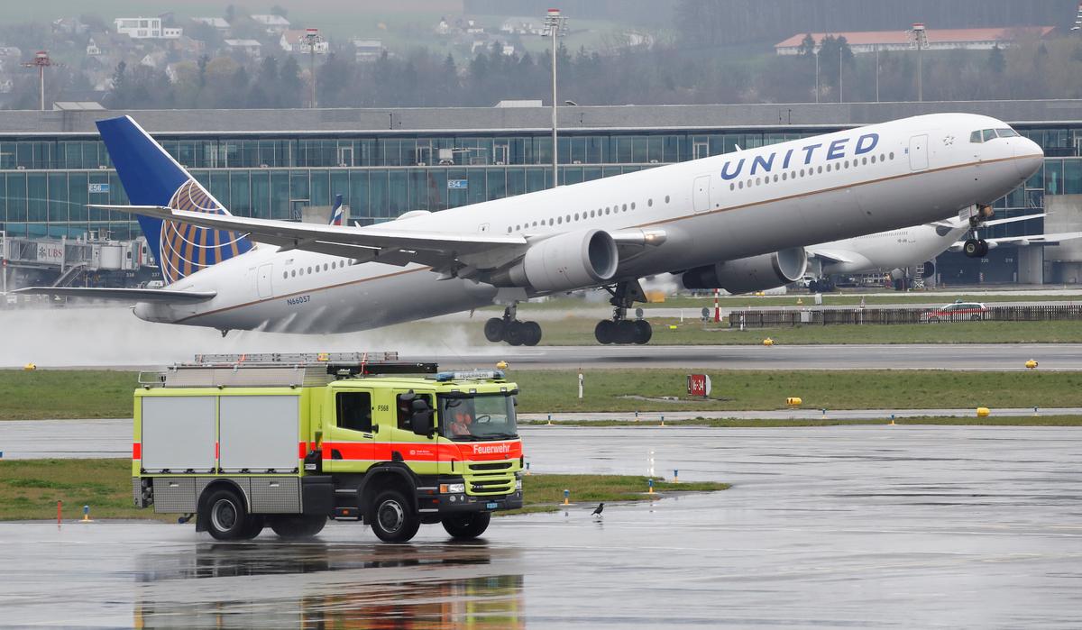 A vehicle of the airport rescue and firefighting services stands in front as a Boeing 767-400ER aircraft of United Airlines takes off from Zurich airport, April 9, 2019. (Reuters/Arnd Wiegmann)
