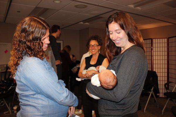 Andrea Moffat (L), admires Kate Galecki’s newborn daughter at a session of CenteringPregnancy at Northwestern Medicine in Chicago. Over the past five years, the number of practices that offer the program has nearly doubled. (Jenny Gold/Kaiser Health News)