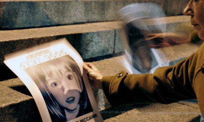 A woman holds a picture of missing British girl Madeleine McCann next to another of a missing Argentine child, during a demo by Missing Children Argentina and Red Solidaria organizations near the British embassy in Buenos Aires 11 June, 2007. (JUAN MABROMATA/AFP/Getty Images)