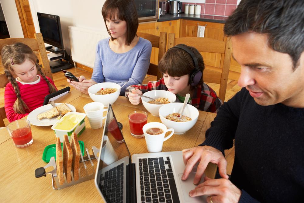 Illustration - Shutterstock | <a href="https://www.shutterstock.com/image-photo/family-using-gadgets-whilst-eating-breakfast-114544525?studio=1">Monkey Business Images</a>