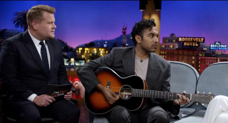 James Corden (L), as a talk show host, interviewing a man, played by Himesh Patel, who remembers The Beatles when no one else in the world does, in “Yesterday.” (Jonathan Prime/Universal Pictures)