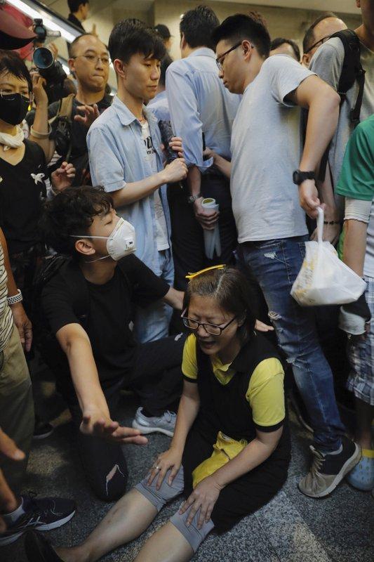 A protester sits down to block visitors in the lobby of the Hong Kong Revenue Tower in Hong Kong on June 24, 2019. (Kin Cheung/AP)