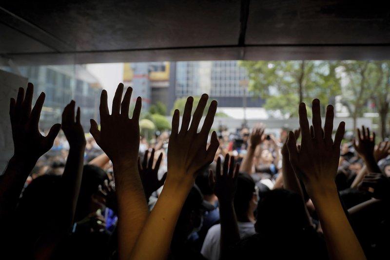 Protesters gesture inside the Hong Kong Revenue Tower as they block the building lobby to prevent people from entering in Hong Kong on June 24, 2019. Mass protests in recent weeks have occurred in Hong Kong over legislation that was seen as increasing Beijing's control and over police treatment of the protesters. (Kin Cheung/AP)