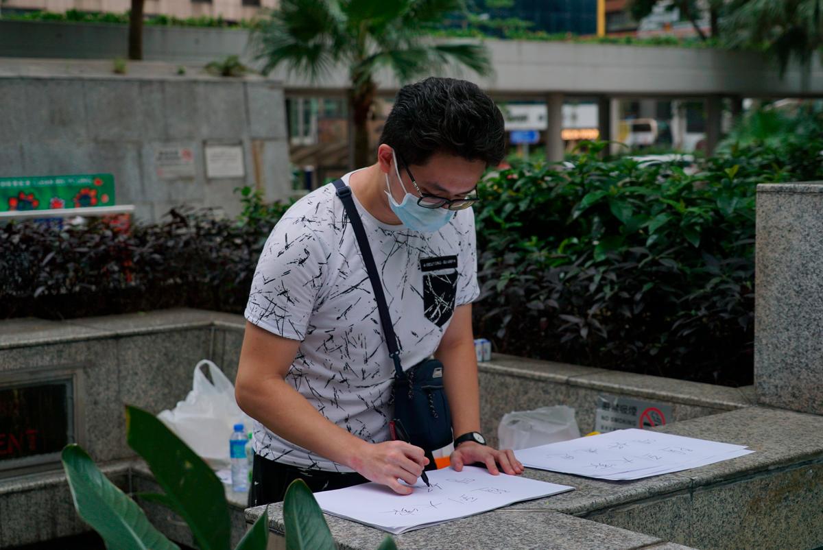 A protestor writes notes to apologize for a demonstration that jammed the entrance of a government tax office in Hong Kong on June 25, 2019. (Dake Kang/AP)