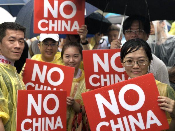 Protesters hold up signs at a rally against pro-Beijing Taiwanese media in Taipei, Taiwan, on June 23, 2019. (Chen Pochou/The Epoch Times)