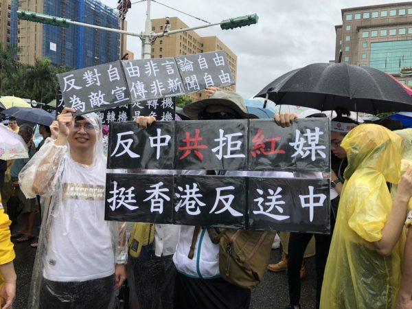 A protester holds up a sign with the words "Reject Chinese Communist Party and Red Media, Support Hong Kong Protest Against Extradition Bill," in a rally in Taipei, on June 23, 2019. (Chen Pochou/The Epoch Times)