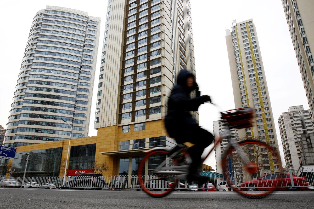 A woman cycles past a building registered to Huaying Haitai Science and Technology Development Co. in Tianjin, China, the alleged employer of two Chinese nationals indicted by the United States on hacking charges, on Dec. 21, 2018. (Thomas Peter/Reuters)