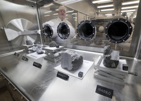 Ryan Zeigler, Apollo sample curator, left, stands next to a nitrogen-filled case displaying various lunar samples collected during Apollo missions 15, 16 and 17, inside the lunar lab at the NASA Johnson Space Center in Houston on June 17, 2019. (Michael Wyke/AP)
