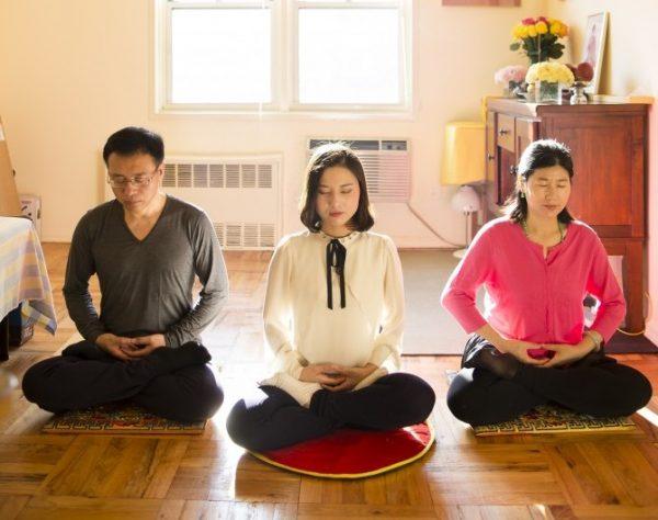 Li Zhenjun, Li Fuyao, and Wang Huijuan do the Falun Gong meditation at their home in Queens, New York. (Samira Bouaou/Epoch Times)