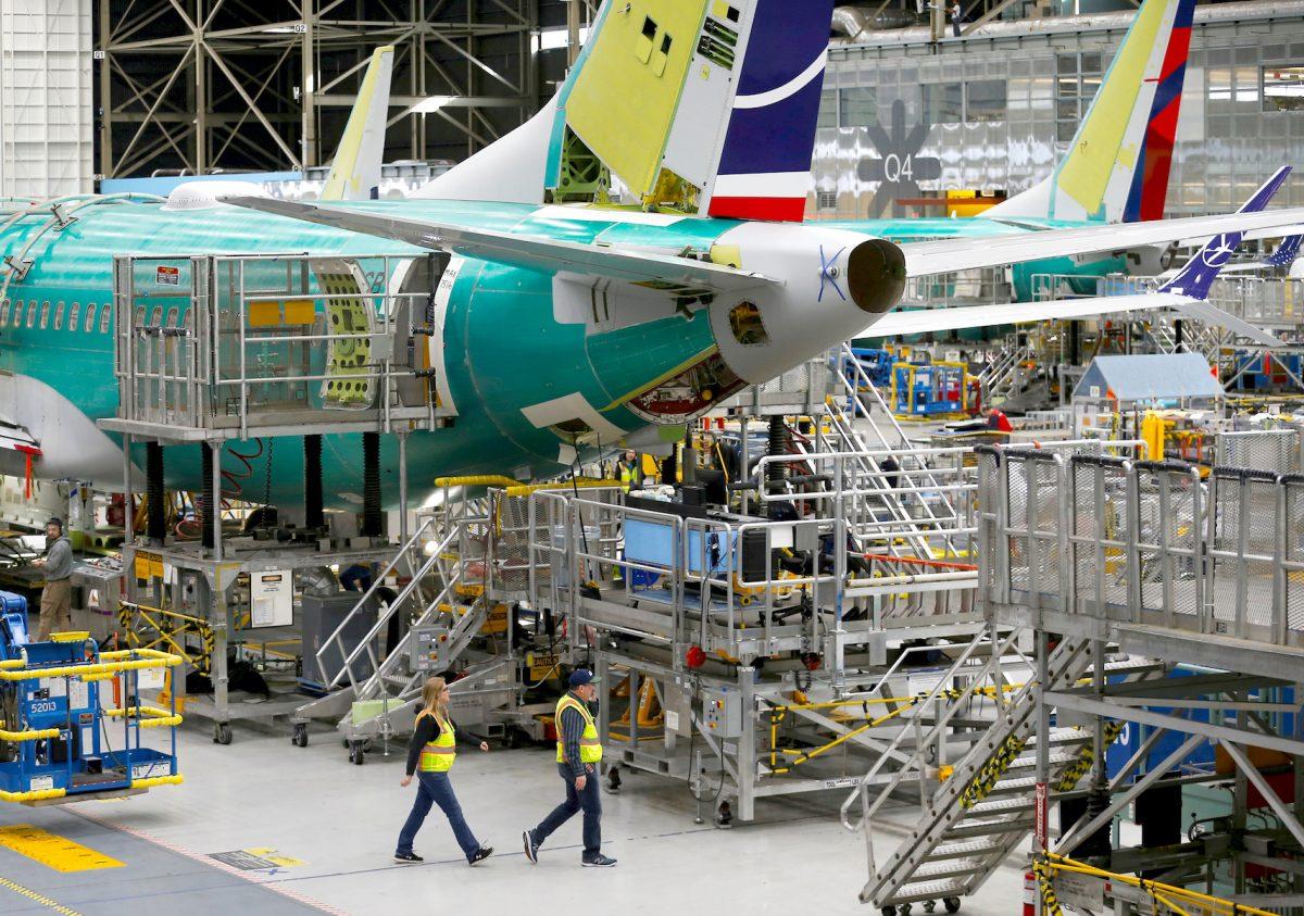 Employees walk by the end of a 737 Max aircraft at the Boeing factory in Renton, Washington, on March 27, 2019. (Lindsey Wasson/Reuters)