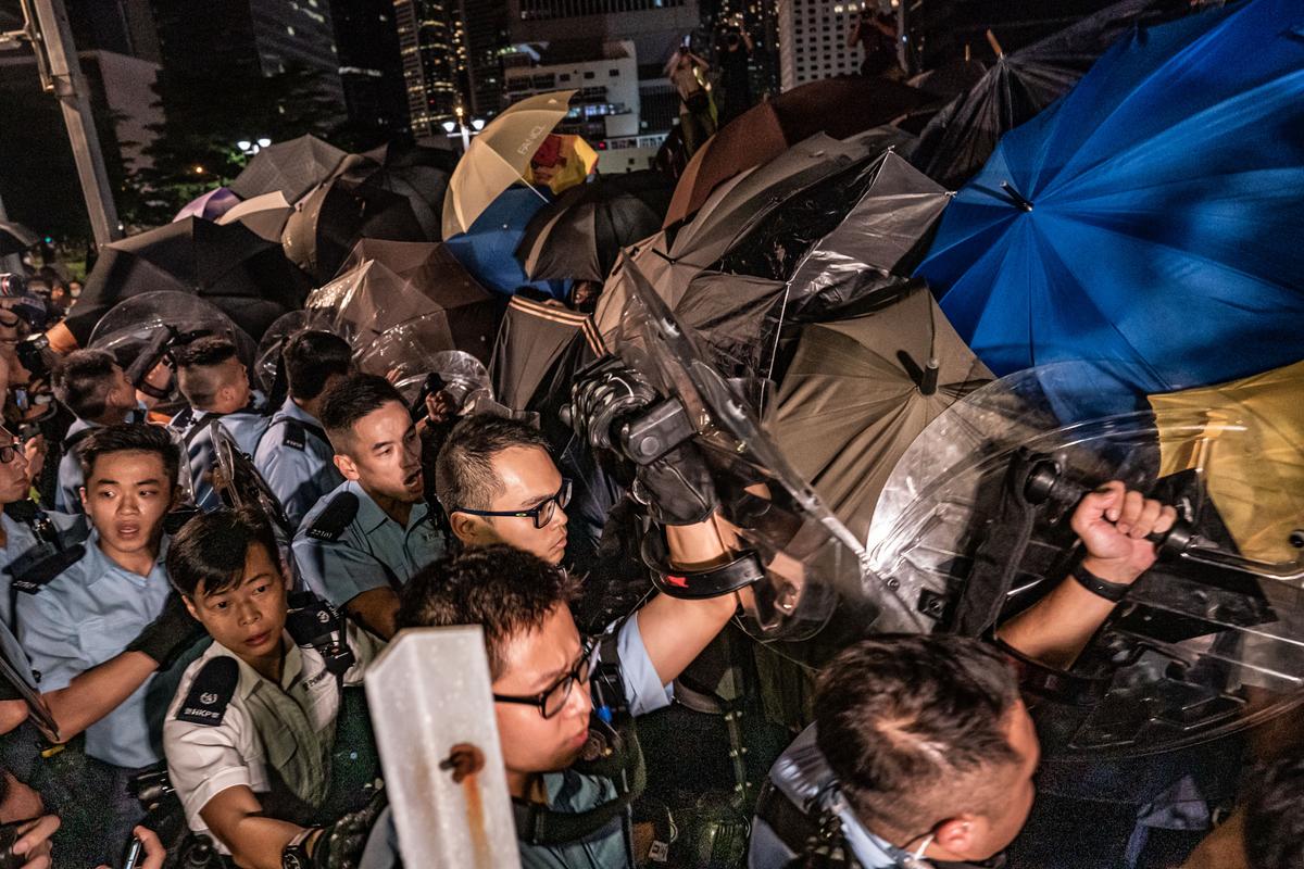 Protesters scuffle with police officers as they hold up umbrellas to defend themselves at the Central Waterfront on June 28, 2019 in Hong Kong, China. (Anthony Kwan/Getty Images)