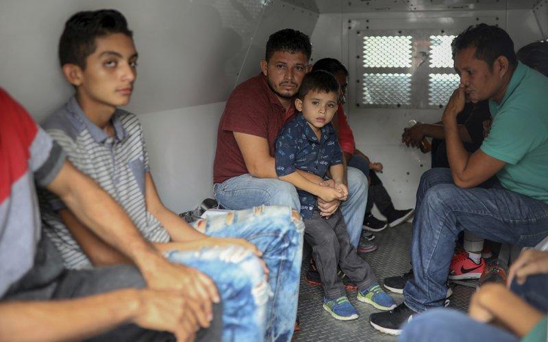 Central American migrants sit inside an immigration van during a raid on the Latino hotel by Mexican immigration agents in Veracruz, Mexico, June 27, 2019. (AP Photo/Felix Marquez)