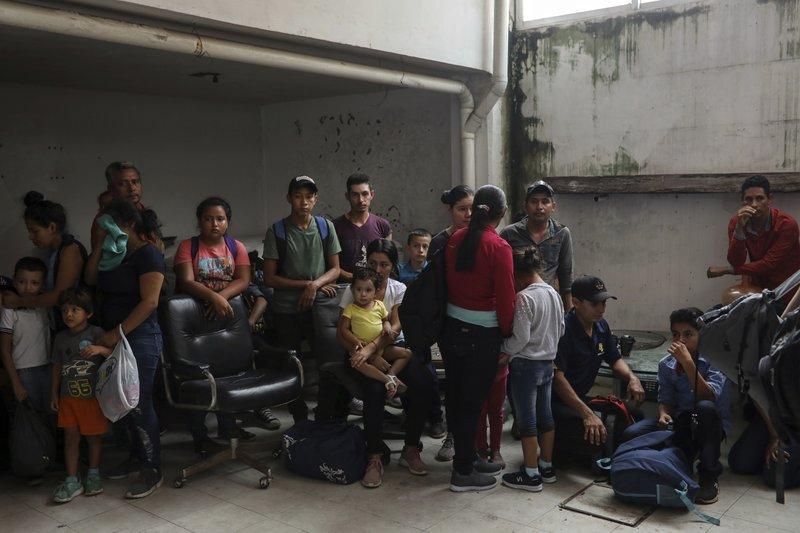 Migrants stand together as they're detained at the Azteca Hotel during a raid by Mexican immigration agents in Veracruz, Mexico, June 27, 2019. (AP Photo/Felix Marquez)