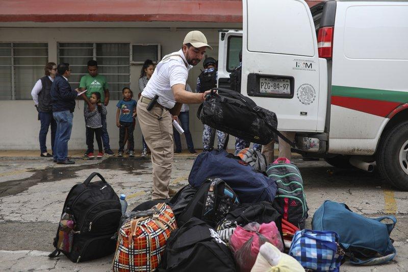 A Mexican immigration agent organizes the luggage of detained Central American migrants during a raid on the Latino hotel in Veracruz, Mexico, June 27, 2019. (AP Photo/Felix Marquez)