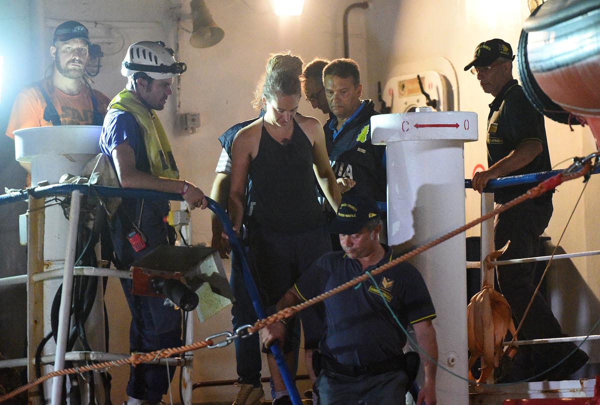 Carola Rackete, the 31-year-old Sea-Watch 3 captain, is escorted off the ship by police and taken away for questioning, in Lampedusa, Italy June 29, 2019. (Reuters/Guglielmo Mangiapane)