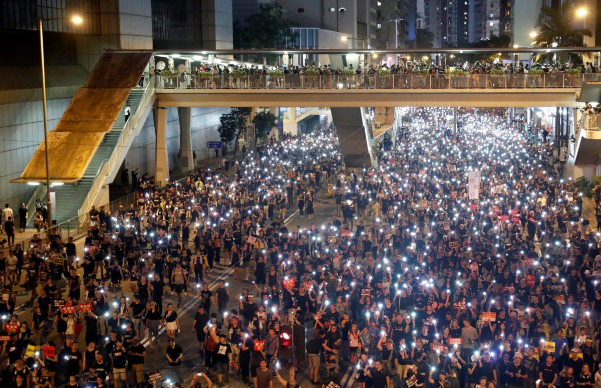 Anti-extradition bill protesters use the flashlights from their phones as they march during the anniversary of Hong Kong's handover to China in Hong Kong on July 1, 2019. (Tyrone Siu/Reuters)