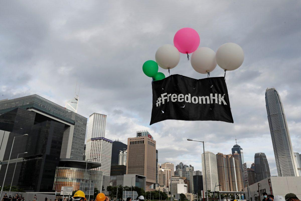 Protesters release balloons carrying a banner near a flag raising ceremony for the anniversary of Hong Kong's handover to China in Hong Kong, China on July 1, 2019. (Tyrone Siu/Reuters)