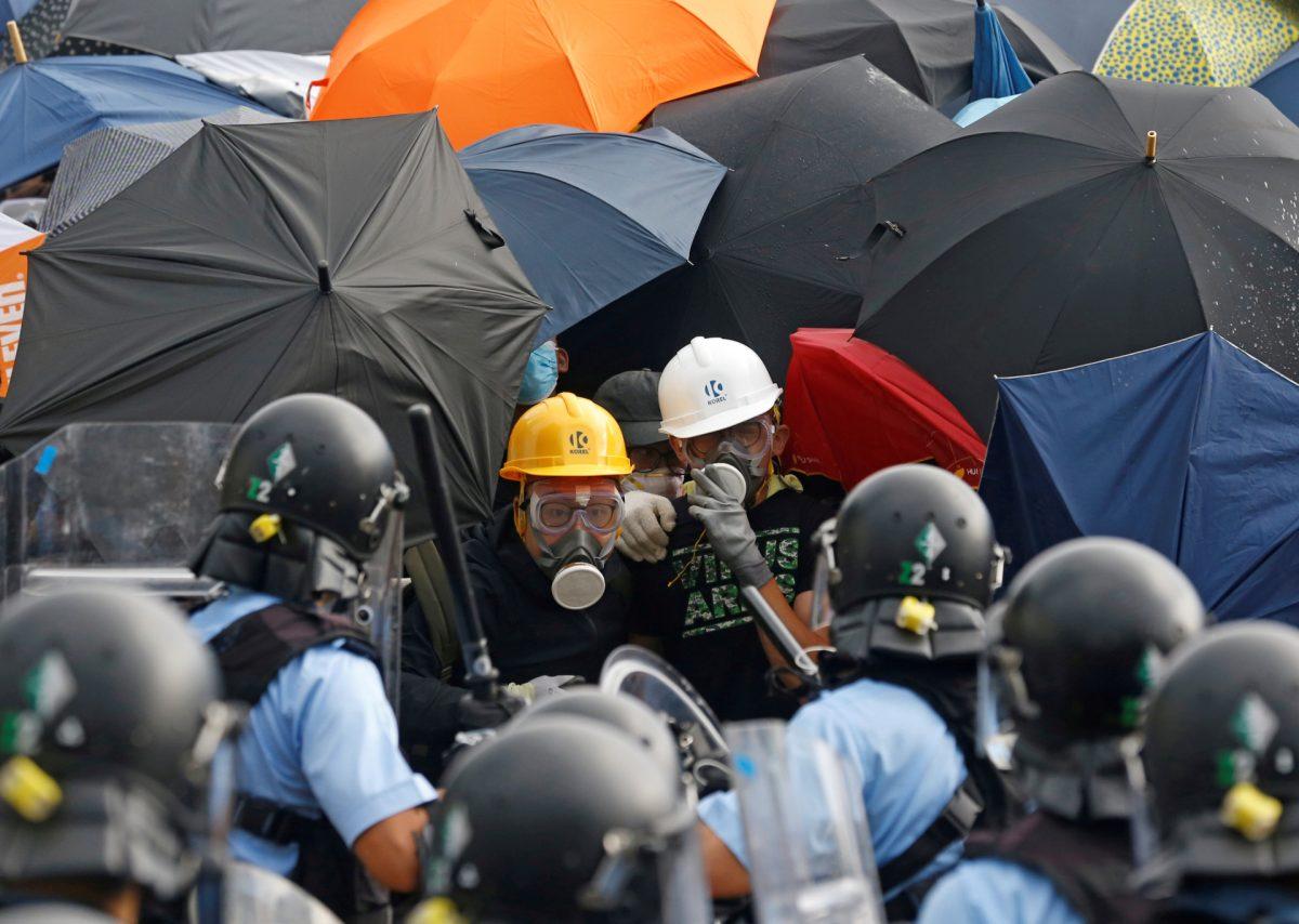 Riot police try to disperse protesters near a flag raising ceremony for the anniversary of Hong Kong handover to China in Hong Kong, China on July 1, 2019. (Thomas Peter/Reuters)
