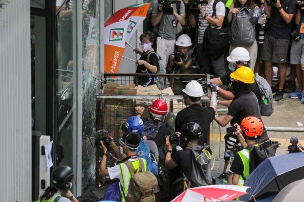 Rogue protesters try to push a metal cart through a closed entrance at the government headquarters in Hong Kong on July 1, 2019 on the 22nd anniversary of the city's handover from Britain to China. (VIVEK PRAKASH/AFP/Getty Images)