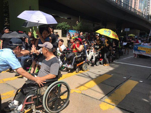 Protesters in wheelchairs take part in the march in Hong Kong on July 1, 2019. (Lin Yi/The Epoch Times)