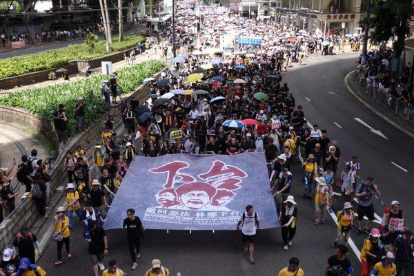 Protesters carry a gigantic banner with the words “Withdraw the evil law, Carrie Lam step down” in Chinese on July 1, 2019. (Yu Gang/The Epoch Times)