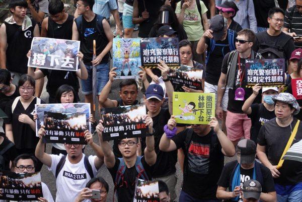 Protesters hold up different signs while participating in a march in Hong Kong on July 1, 2019. (Yu Gang/The Epoch Times)