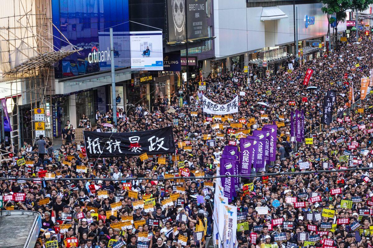 Protesters march on Hong Kong streets with a sign that reads "Resist Tyranny" during the annual rally on July 1, 2019. (Yu Gang/The Epoch Times)