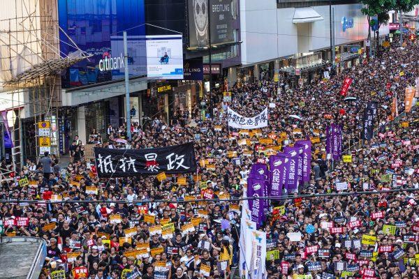 Protesters hold up a sign that reads "Resist Tyranny" at a rally, said by organizers to be about 550,000-strong, to demand the withdrawal of a controversial extradition bill in Hong Kong on July 1, 2019. (Yu Gang/The Epoch Times)