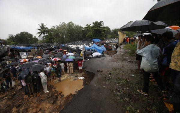 Rescuers and others gather at the spot after heavy rainfall caused a wall to collapse onto shanties, in Mumbai, India on July 2, 2019. (Rafiq Maqbool/Photo AP)