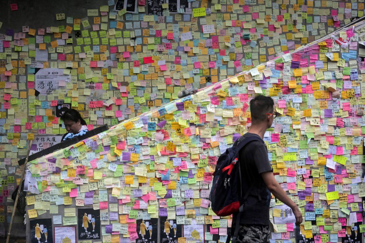 People walk past notes left by protesters on the walls of the government headquarters in Hong Kong on July 2, 2019. (Vivek Prakash/AFP/Getty Images)
