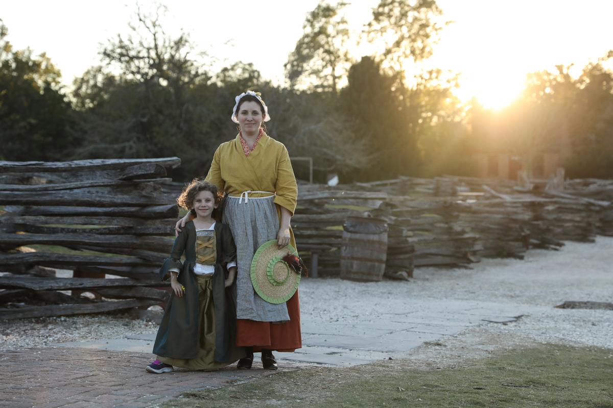 A mother and daughter, dressed in period garb, walk through the streets of historic Williamsburg. (Samira Bouaou/The Epoch Times)