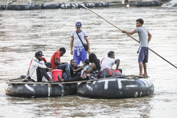 A group of Africans from Angola and The Congo illegally cross the Suchiate River on a tube raft from Tecun Uman, Guatemala, to Hidalgo City, Mexico, on June 27, 2019. (Charlotte Cuthbertson/The Epoch Times)