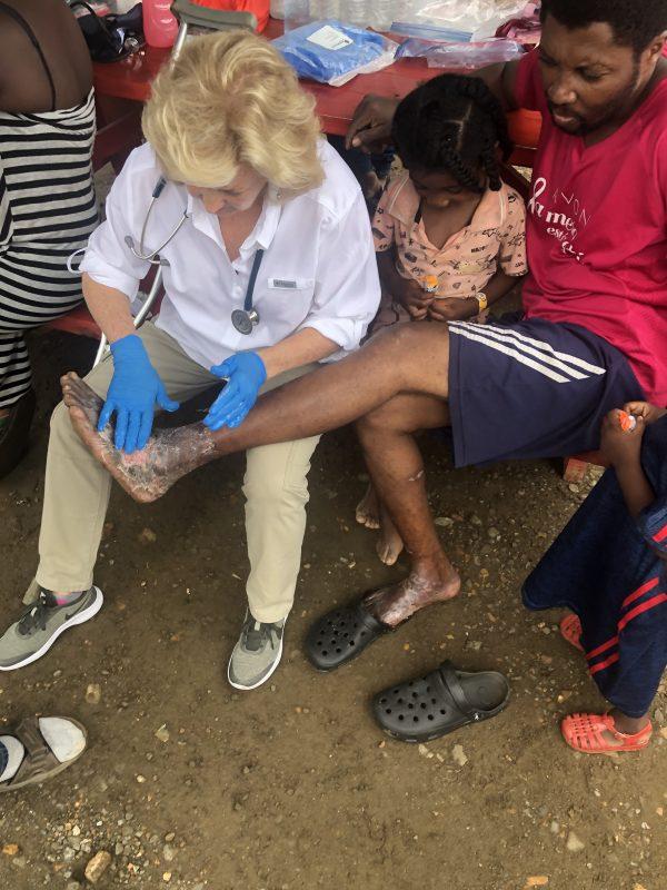 Diana Edrington treats an African man's foot in a Panama migrant camp after he traveled through the Colombian jungle, in June, 2019. (Courtesy of Diane Edrington)