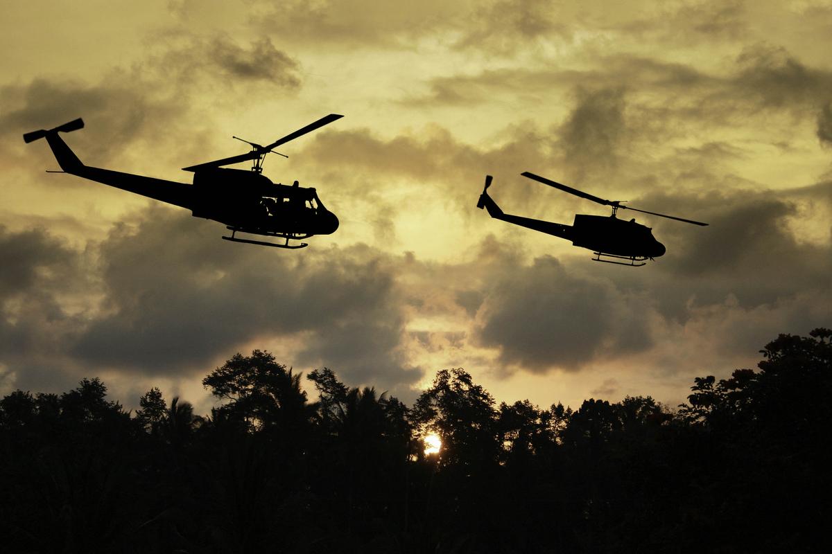 Illustration - Shutterstock | <a href="https://www.shutterstock.com/pt/image-illustration/vietnam-war-style-image-two-helicopters-140748628?studio=1">Keith Tarrier</a>