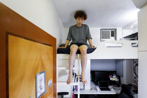 Hong Kong resident Fung Cheng, 25, in his 54 square foot bedroom of his family's apartment in Hong Kong on June 27, 2019. (Thomas Peter/Reuters)