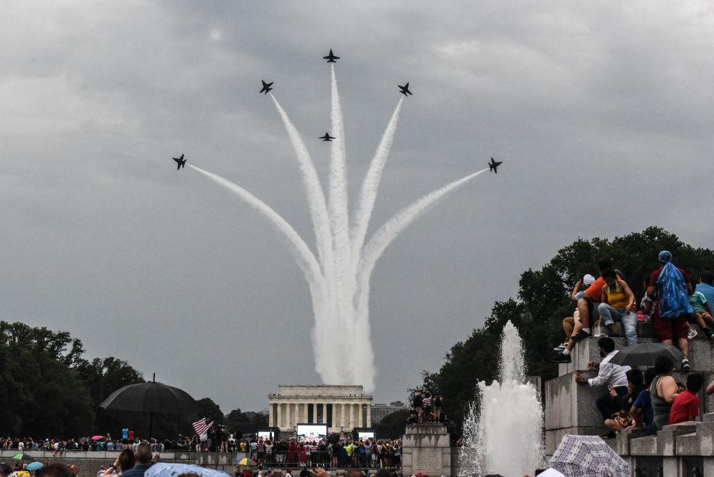 People react to a military fly over on the National Mall while President Donald Trump gives his speech during Fourth of July festivities on July 4, 2019 in Washington, DC. (MANDEL NGAN/AFP/Getty Images)
