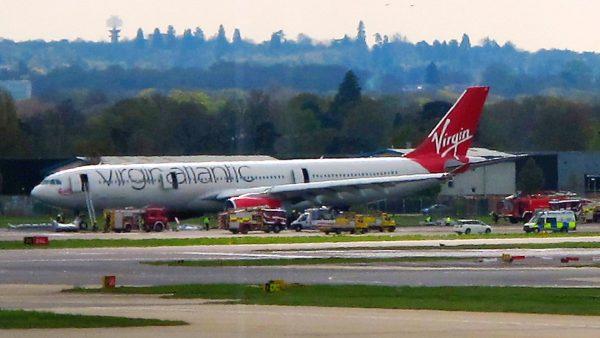 A Virgin Atlantic aircraft stands on the tarmac with emergency service vehicles in support after making an emergency landing at Gatwick Airport in London, England on April 16, 2012. (Scott Heavey/File Photo via Getty Images)