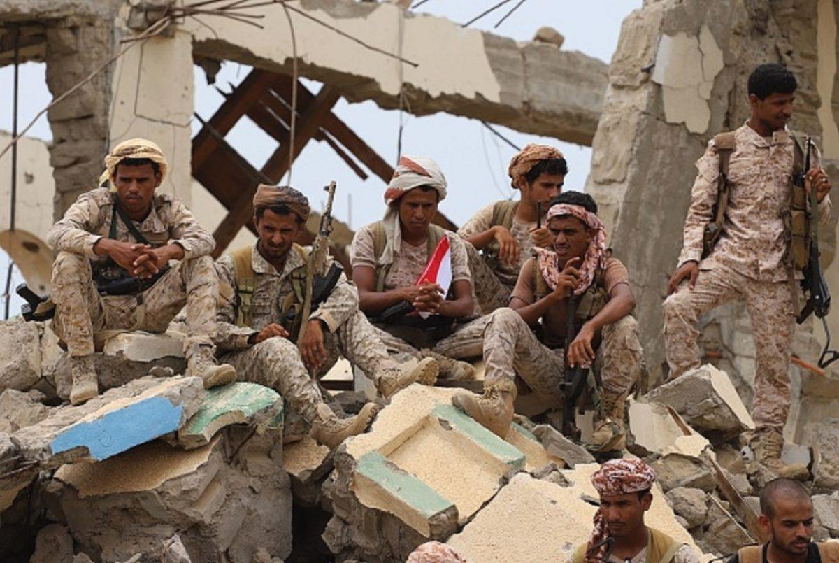 Saudi-backed Yemeni fighters gather above debris of a building while watching the launch by Saudi Development and Reconstruction Program for Yemen (SDRPY) of multi-million dollar aid projects in the area of Yemen's northern coastal town of Midi, located in conflict-ridden Hajjah governorate near the border with Saudi Arabia, on April 22, 2019. (AFP/Getty Images)