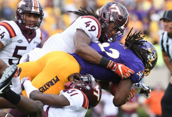 File photo showing then running back Tyshon Dye #22 of the East Carolina Pirates being tackled by linebacker Tremaine Edmunds #49 and cornerback Brandon Facyson #31 of the Virginia Tech Hokies in the first half at Dowdy-Ficklen Stadium in Greenville, North Carolina, on September 16, 2017. (Michael Shroyer/Getty Images)