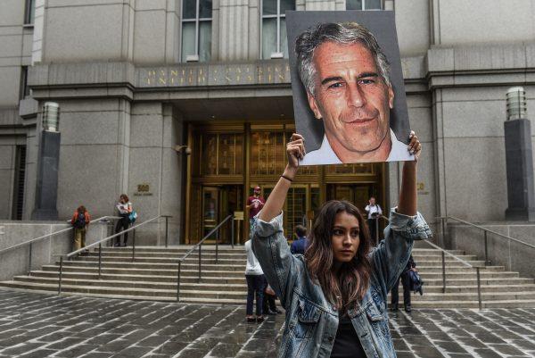 A protest group called "Hot Mess" hold up signs of Jeffrey Epstein in front of the federal courthouse in New York City on July 8, 2019. (Stephanie Keith/Getty Images)