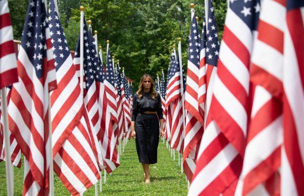 US First Lady Melania Trump walks through 453 American flags, each representing a child in foster care in Cabell County, West Virginia, many due to the opioid epidemic, at Ritter Park in Huntington, West Virginia, on July 8, 2019. (SAUL LOEB/AFP/Getty Images)
