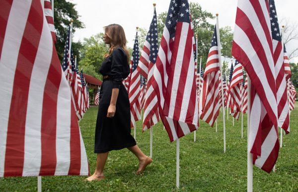 US First Lady Melania Trump walks through 453 American flags, each representing a child in foster care in Cabell County, West Virginia, many due to the opioid epidemic, at Ritter Park in Huntington, West Virginia, on July 8, 2019. (SAUL LOEB/AFP/Getty Images)