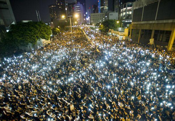 Protestors hold up their cellphones during a protest to demand universal suffrage outside the government headquarters in Hong Kong on September 29, 2014. (XAUME OLLEROS/AFP/Getty Images)