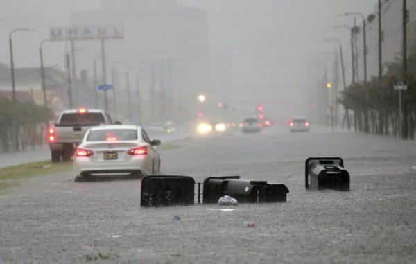 Vehicles head down a flooded Tulane Ave. as heavy rain falls in New Orleans on July 10, 2019. (David Grunfeld/The Advocate via AP)