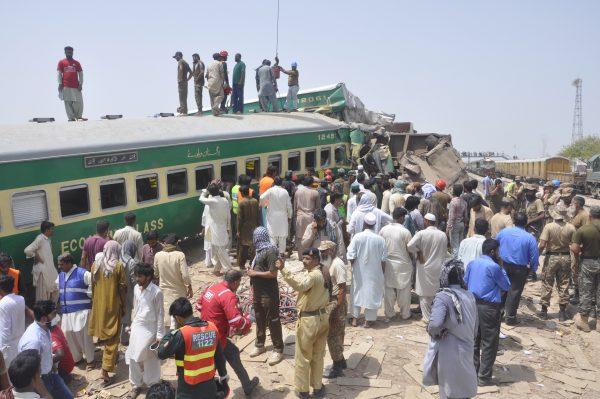 Pakistani officials and volunteers work at a train crash site in Rahim Yar Khan, Pakistan on July 11, 2019. (Waleed Saddique/AP)