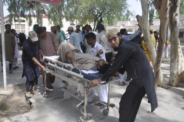 People rush an injured passenger to a hospital in Rahim Yar Khan, Pakistan on July 11, 2019. (Waleed Saddique/AP)